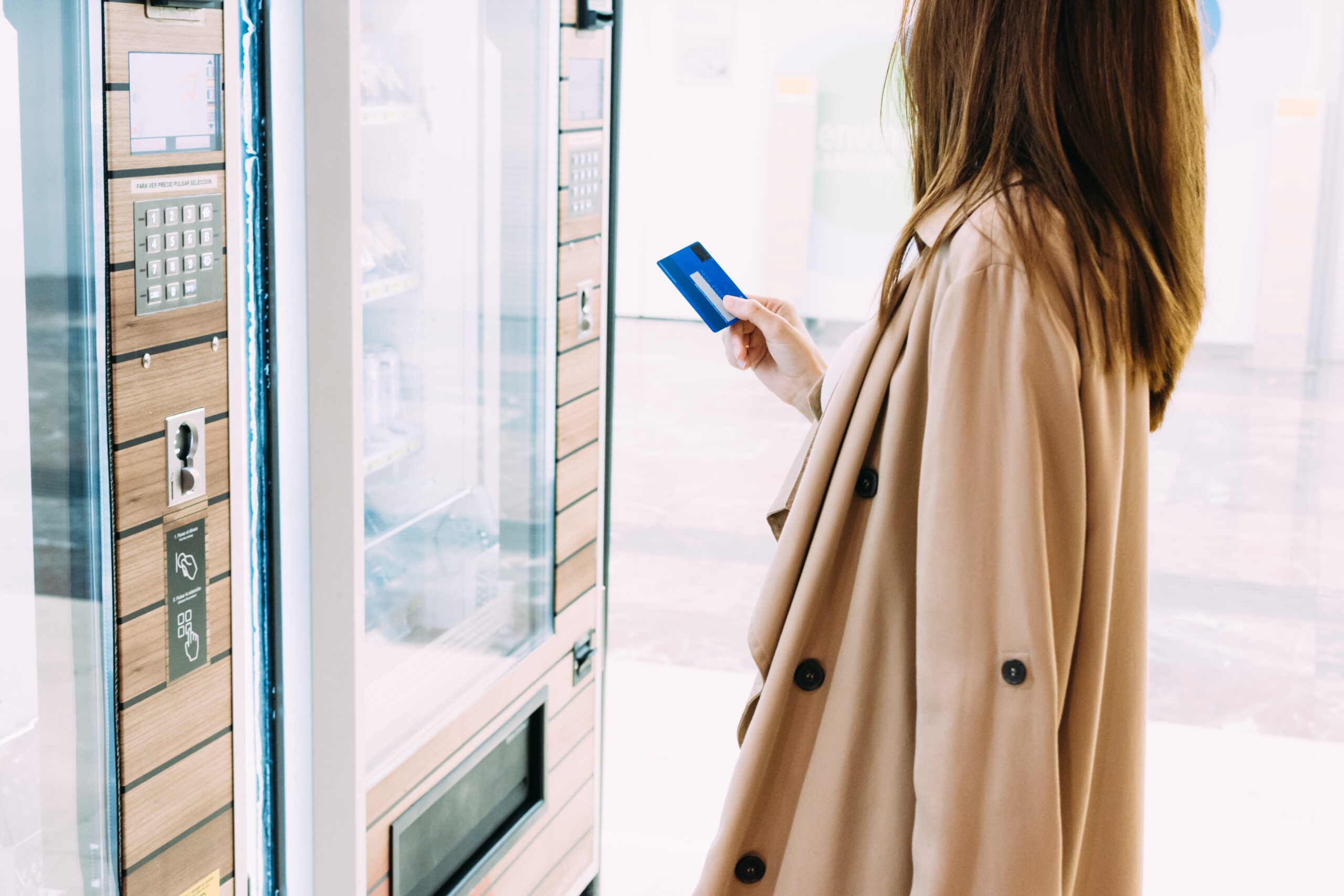 woman uses her credit card to pay at the vending machine